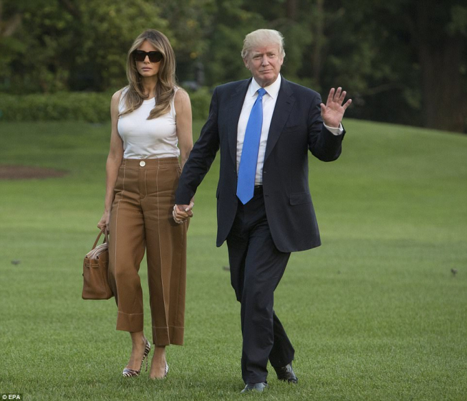 Tổng thống Donald Trump nắm chặt tay Đệ nhất phu nh&acirc;n Melania Trump. (Ảnh: EPA)