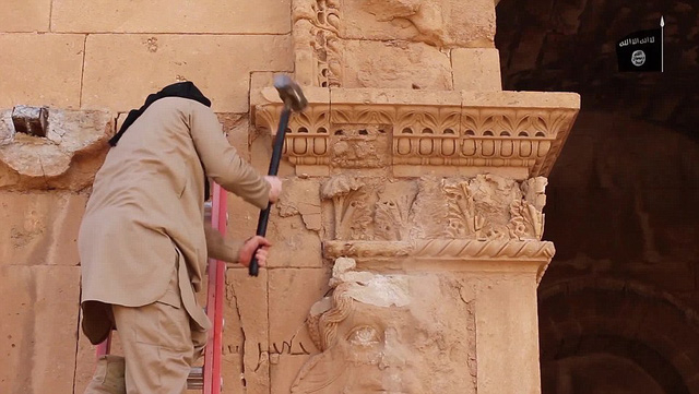Một th&agrave;nh vi&ecirc;n của IS ph&aacute; bỏ những tượng cổ ở khu Hatra. (Ảnh: Dailymail).