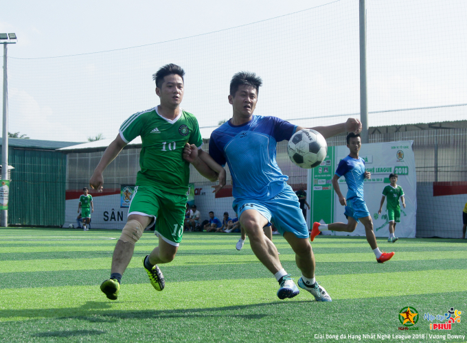 Pha tranh chấp b&oacute;ng giữa cầu thủ FC Đi M&ocirc; Ri (&aacute;o xanh) v&agrave; cầu thủ FC Quỳnh Lưu (&aacute;o xanh nước biển).