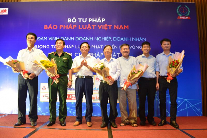 Đại diện lãnh đạo Báo Pháp luật Việt Nam tặng hoa cho các đại diện Sở ban ngành TP. Đà Nẵng và Bộ tư lênh Quân khu 5 tham dự Tọa đàm.