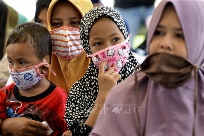 Phụ nữ và trẻ em đeo khẩu trang phòng dịch COVID-19 ở Blang Bintang, tỉnh Aceh, Indonesia ngày 6/5/2020. Ảnh: AFP/TTXVN