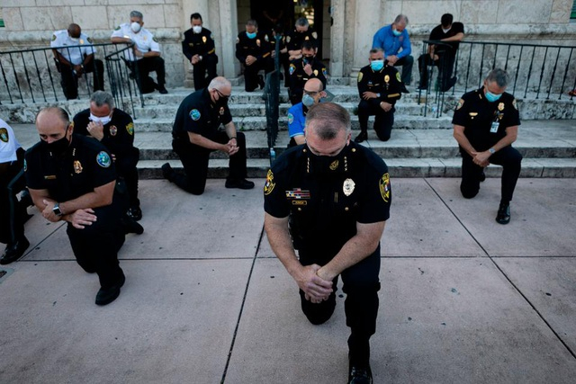 Cảnh sát Mỹ quỳ gối tại Coral Gables, bang Florida để thể hiện sự chia sẻ với những người biểu tình sau cái chết của George Floyd. (Ảnh: AFP)