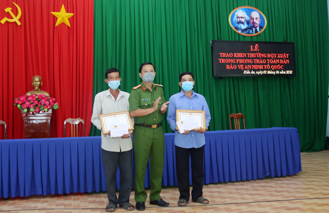 Đại tá Lê Phú Thạnh, Phó Giám đốc Công an tỉnh An Giang trao giấy khen và tiền thưởng cho 2 anh Nguyễn Văn Nghí và Nguyễn Văn Nhận