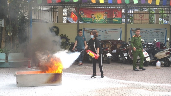 Cảnh sát PCCC quận Lê Chân hướng dẫn sử dụng cán bộ trường tiểu học Trưng Vương sử dụng bình chữa cháy.