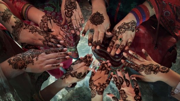 Phụ nữ Pakistan vẽ những hoa văn Henna truyền thống l&ecirc;n tay trước ng&agrave;y lễ Eid al-Fitr. (Ảnh: AP)
