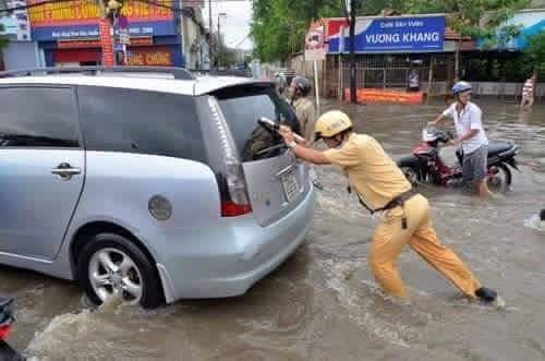 Gồng m&igrave;nh đẩy xe ra khỏi khu vực ngập lụt.(Nguồn: Facebook).