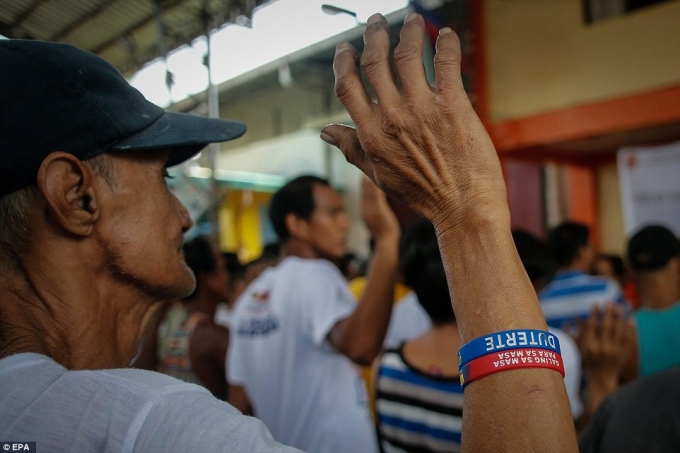 Một người nghiện giơ tay thề sẽ cai nghiện sau khi đầu th&uacute; ở Manila. (Ảnh: EPA)