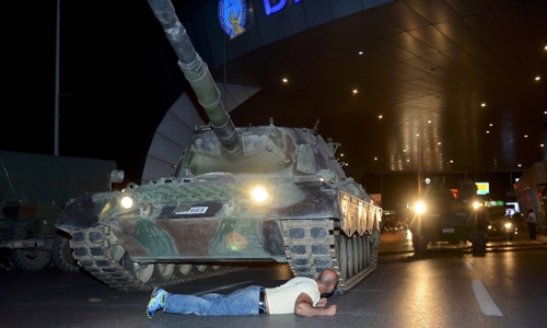 Metin Dogan nằm trước xe tăng tại&nbsp;s&acirc;n bay Ataturk ở Istanbul đ&ecirc;m 15/7. (Ảnh:&nbsp;Reuters)