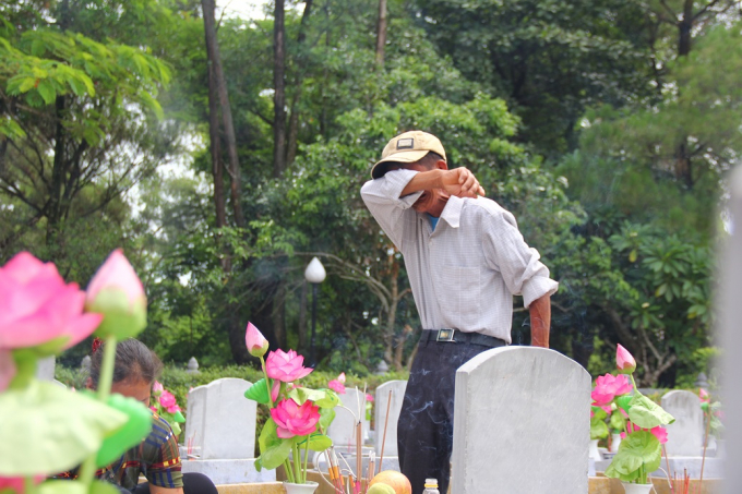 &Ocirc;ng L&ecirc; Văn Nguy&ecirc;n kh&oacute;c nức nở trước bia mộ của anh trai tại nghĩa trang Quốc gia Trường Sơn.