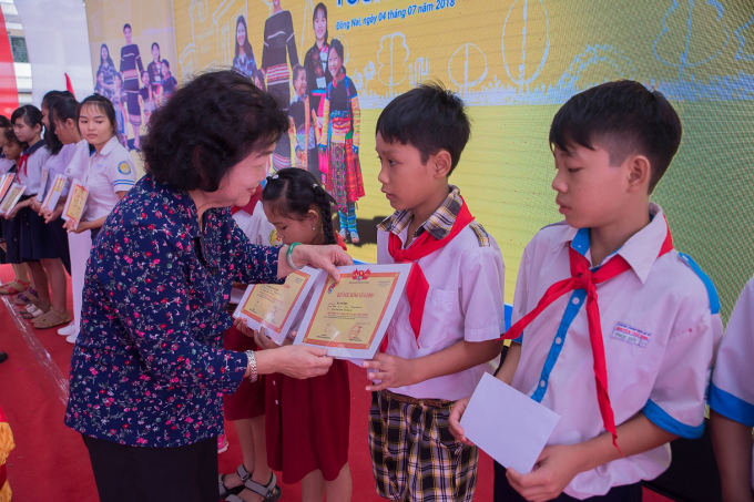 B&agrave; Trương Mỹ Hoa trao những phần học bổng cho c&aacute;c em học sinh tiểu học.