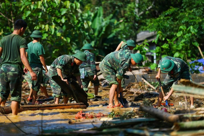 Lực lượng vũ trang tham gia khắc phục hậu quả mưa lũ tại huyện Văn Chấn (Y&ecirc;n B&aacute;i) ng&agrave;y 22.7. Ảnh: SƠN T&Ugrave;NG