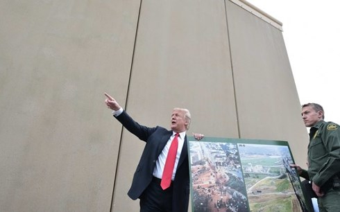Tổng thống Donald Trump đứng b&ecirc;n bức tường mẫu sẽ được dựng l&ecirc;n dọc bi&ecirc;n giới Mỹ-Mexico. Ảnh: AFP/Getty