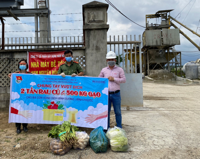 Anh Phạm Huy Hùng, Bí thư Chi đoàn Công an huyện Đồng Phú (chính giữa) trao rau, củ, quả vận động từ Hệ thống mỹ phẩm BICO CLINIC cho công nhân một công ty ở KCN Bắc Đồng Phú