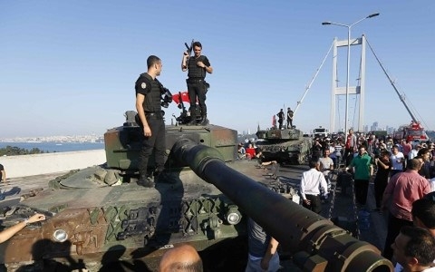 Cảnh s&aacute;t Thổ Nhĩ Kỳ đứng tr&ecirc;n một chiếc xe tăng tham gia cuộc đảo ch&iacute;nh bất th&agrave;nh.
