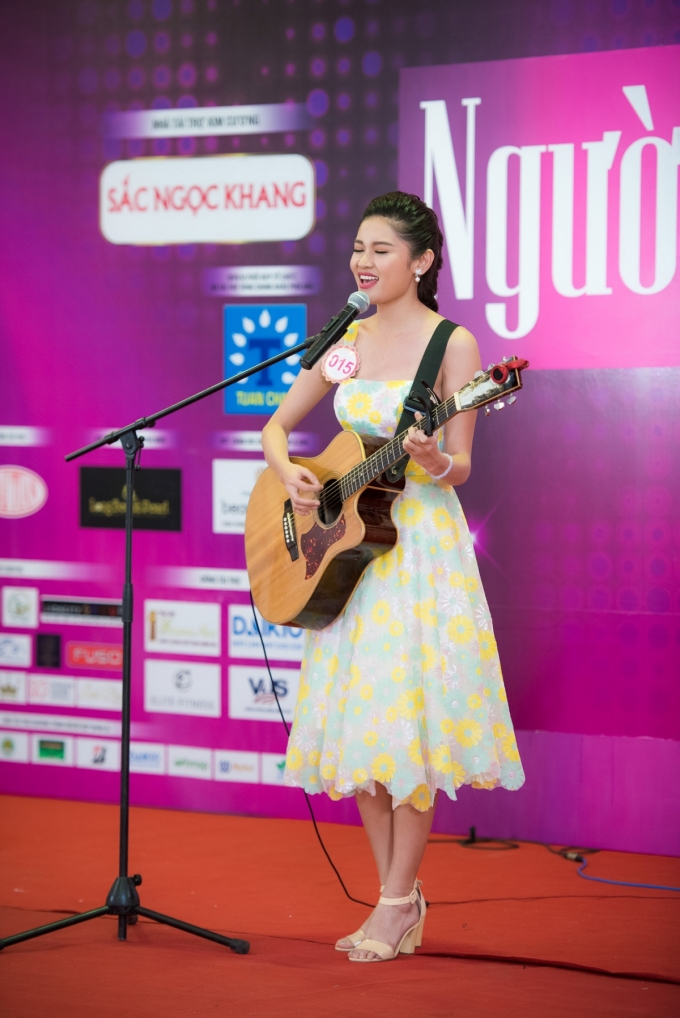Huỳnh Thị Thuỳ Dung (SBD 015) mặc v&aacute;y hoa thanh lịch, vừa đệm đ&agrave;n guitar vừa thể hiện ca kh&uacute;c tiếng Anh