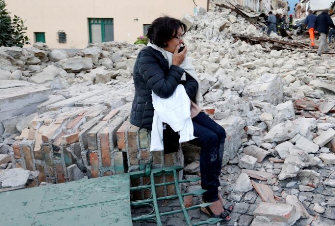 Một phụ nữ sợ h&atilde;i sau trận động đất tr&ocirc;n v&ugrave;i 1 nửa th&agrave;nh phố Amatrice. (Ảnh: Reuters)