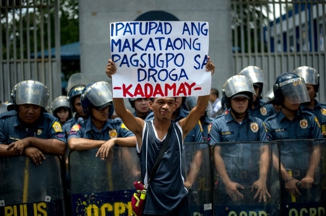 Một nh&agrave; hoạt động nh&acirc;n quyền giơ biển phản đối chiến dịch trấn &aacute;p tội phạm ma t&uacute;y của &ocirc;ng Duterte. (Ảnh: AFP)