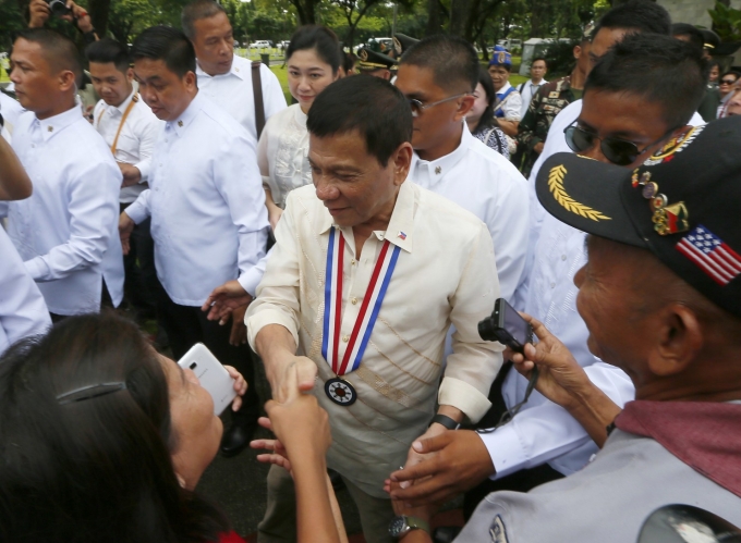 Tổng thống Duterte bắt tay c&aacute;c kh&aacute;ch mời trong ng&agrave;y Anh h&ugrave;ng Quốc gia. (Ảnh: AP)