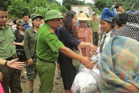 Thiếu t&aacute; Nguyễn Anh Tuấn (đội mũ cối) hỗ trợ trao qu&agrave; từ thiện cho b&agrave; con ở x&atilde; Huổi Liếng.