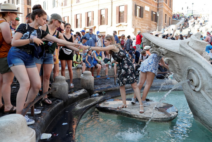Kh&aacute;ch du lịch lấy nước từ đ&agrave;i phun nước Barcaccia gần Quảng trường Piazza di Spagna, ItalyẢnh: Alessandro Bianchi/Reuters
