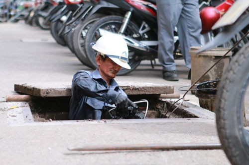 &Ocirc;ng Nguyễn Văn Tuấn đang dọn dẹp r&aacute;c tại một đoạn cống tr&ecirc;n đường L&ecirc; Thạch, quận 4, TP HCM
