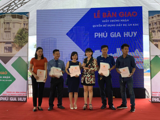 Bà Phạm Thị Hường – Chủ tịch HĐQT Công ty Phú Hồng Thịnh trao sổ cho khách hàng.