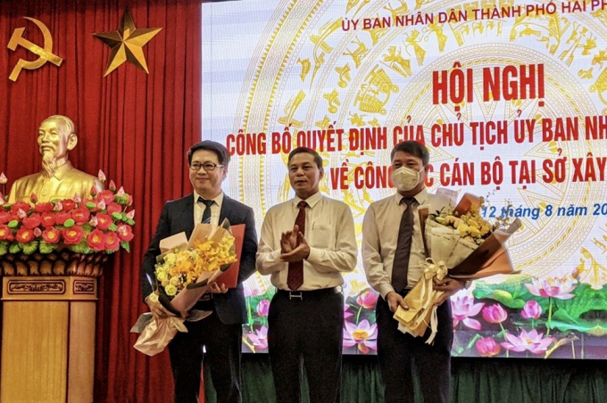 Chủ tịch UBND TP Nguyễn Văn Tùng trao quyết định, tặng hoa chúc mừng đồng chí Nguyễn Thành Hưng và đồng chí Phùng Văn Thanh. Ảnh: CCT