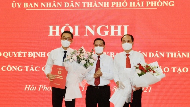 Chủ tịch UBND TP Nguyễn Văn Tùng trao quyết định, tặng hoa chúc mừng đồng chí Bùi Văn Kiệm và đồng chí Lê Quốc Tiến.
