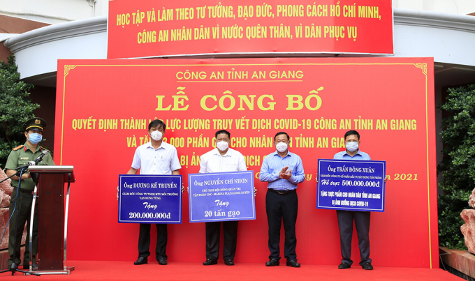 Đồng chí Nguyễn Tiếc Hùng, Chủ tịch UBMTTQVN tỉnh An Giang tiếp nhận bảng hỗ trợ kinh phí và vật chất ủng hộ Chương trình tặng 3.000 phần quà của các mạnh thường quân.