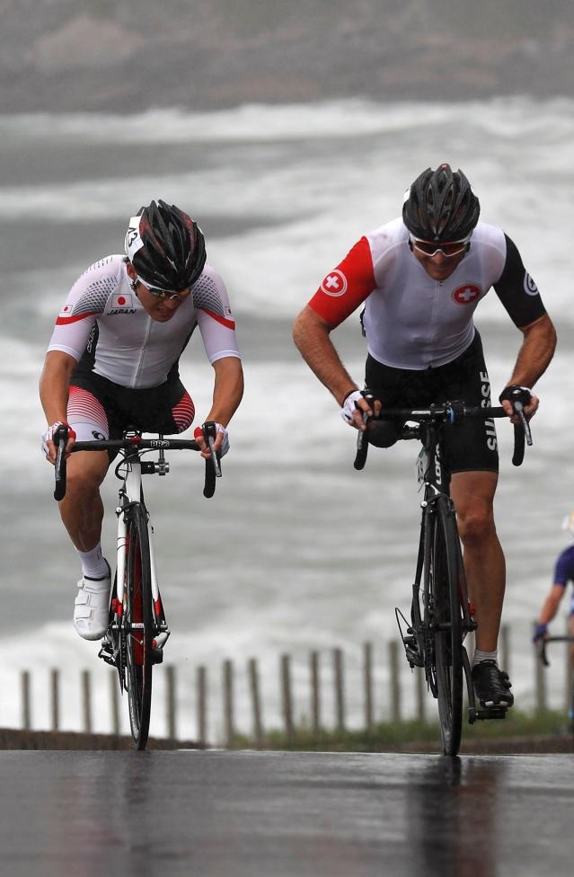 VĐV Roger Bolliger (phải) của Thụy Sĩ v&agrave; Shota Kawamoto của Nhật Bản cạnh tranh nhau trong cuộc đua xe đạp. (Ảnh: Reuters)