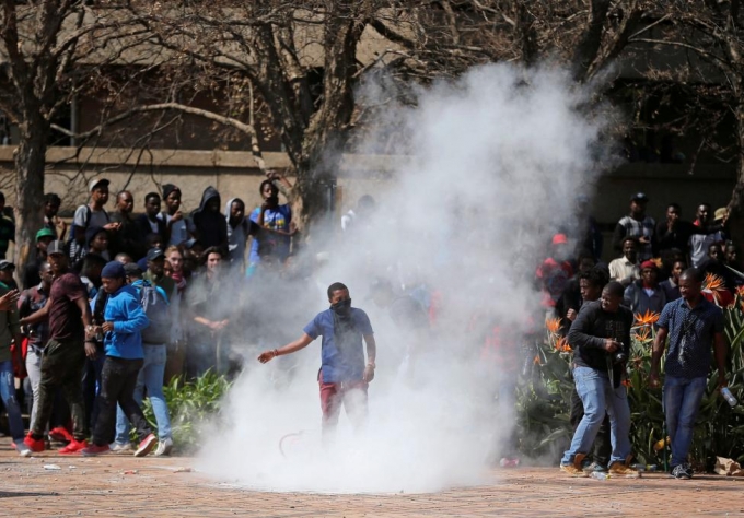 Một học sinh n&eacute;m hơi cay trong cuộc biểu t&igrave;nh ở Đại học&nbsp;Witwatersrand. (Ảnh: Reuters)