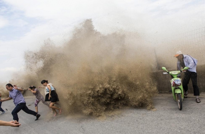 Du kh&aacute;ch bỏ chạy khi cơn b&atilde;o Trami mang theo s&oacute;ng thần đổ bộ v&agrave;o tỉnh Triết Giang năm 2013. (Ảnh: Reuters)