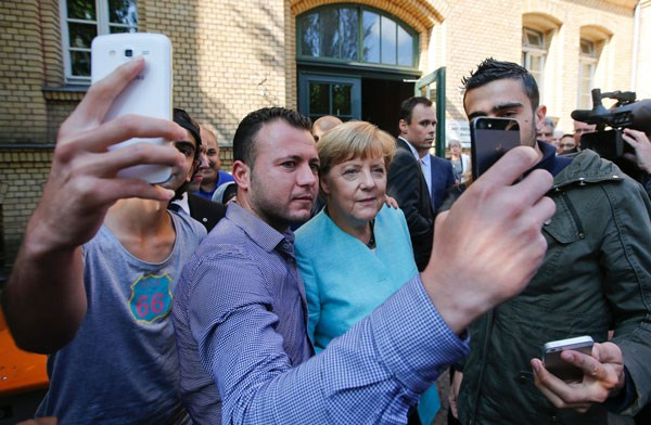 Người tị nạn Syria v&agrave; Iraq selfies với Thủ tướng Đức Angela Merkel b&ecirc;n ngo&agrave;i một Văn ph&ograve;ng Li&ecirc;n bang về di cư v&agrave; người tị nạn ở Berlin.