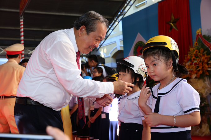 Ph&oacute; Thủ tướng Thường trực Trương H&ograve;a B&igrave;nh tặng mũ bảo hiểm cho c&aacute;c em học sinh.