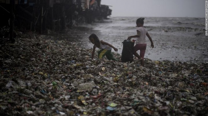 V&agrave;i đứa trẻ đang nhặt r&aacute;c ở khu vực ven biển ở Manila.