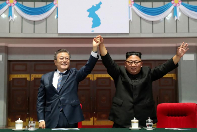 Tổng thống H&agrave;n Quốc Moon Jae-in v&agrave; Nh&agrave; l&atilde;nh đạo Triều Ti&ecirc;n Kim Jong-un nắm tay dưới l&aacute; cờ &ldquo;B&aacute;n đảo Triều Ti&ecirc;n thống nhất&rdquo; sau khi theo d&otilde;i m&agrave;n biểu diễn tại s&acirc;n vận động 1/5, ở thủ đ&ocirc; B&igrave;nh Nhưỡng, Triều Ti&ecirc;n tối 19/9.