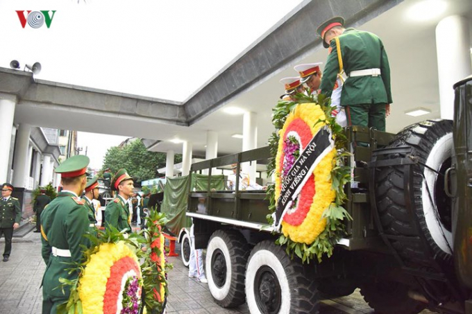 C&aacute;c chiến sĩ trong Đội nghi lễ đang xếp c&aacute;c v&ograve;ng hoa l&ecirc;n xe.