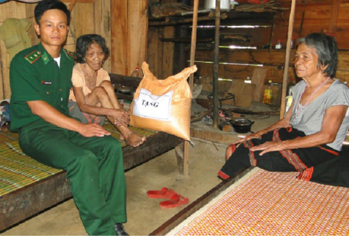 Cán bộ Bộ đội Biên phòng Thừa Thiên Huế tặng gạo cho người già neo đơn ở khu vực biên giới. Ảnh: Viết Hà