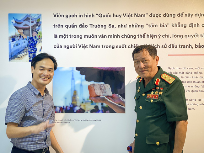Nhà báo Nguyễn Tiến Luyến giới thiệu những hình ảnh của mình với Trung tướng, Anh hùng LLVT Phạm Tuân - người Việt Nam đầu tiên bay vào vũ trụ cùng với Quốc kỳ Việt Nam.