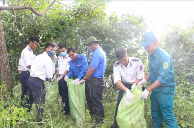 Cán bộ, chiến sĩ BTL Vùng CSB 4 và các ban ngành đoàn thể, nhân dân huyện An Minh thu rác bãi biển cảng cá Xẻo Nhàu.
