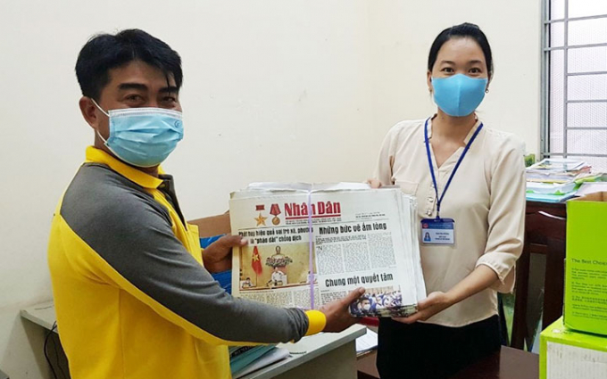Nhân viên Bưu điện Long An giao báo Nhân Dân tại trụ sở UBND xã Tân Ninh, huyện Tân Thạnh (Long An) để tặng người dân đang thực hiện giãn cách.