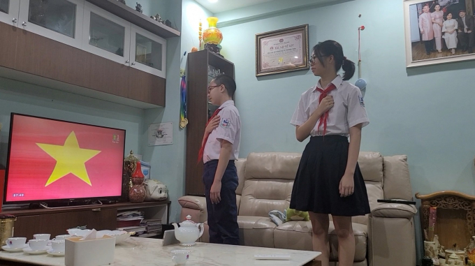 Một gia đình có 2 học sinh Trường THCS Giảng Võ - Ba Đình dự khai giảng năm học mới qua Truyền hình Hà Nội được trực tiếp từ 7h30 sáng nay. Ảnh: Quốc Minh.