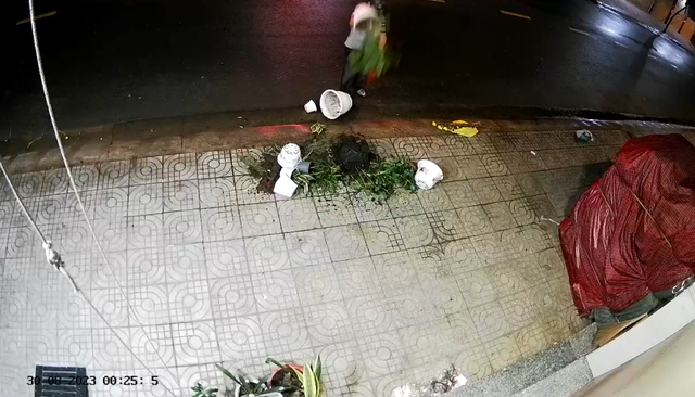 Camera ghi lại một người đàn ông mang các chậu cây ném trước cửa nhà của chị S.  CẮT TỪ CLIP