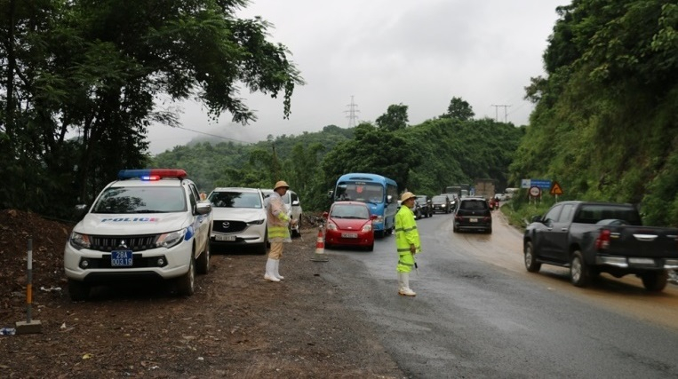 Lực lượng Cảnh sát giao thông phân luồng giao thông tại các vị trí sạt lở trên Quốc lộ 6, đoạn qua Dốc Cun.