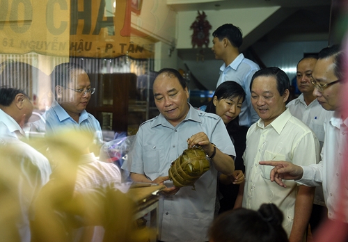 Thủ tướng mua chiếc gi&ograve; lụa&nbsp;ở một cơ sở chế biến thực phẩm phường T&acirc;n Th&agrave;nh (Phường 7, Quận 11).&nbsp;Ảnh: VGP/Quang Hiếu