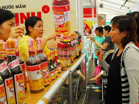 Người ti&ecirc;u d&ugrave;ng chọn mua nước mắm tại hội chợ h&agrave;ng Việt Nam chất lượng cao. Ảnh: HTD