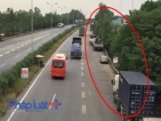 Nhiều xe tải đỗ sai quy định để v&agrave;o qu&aacute;n cơm, qu&aacute;n nước ven đường Quốc lộ 18&nbsp;(đoạn giao với cầu vượt QL3 cũ).