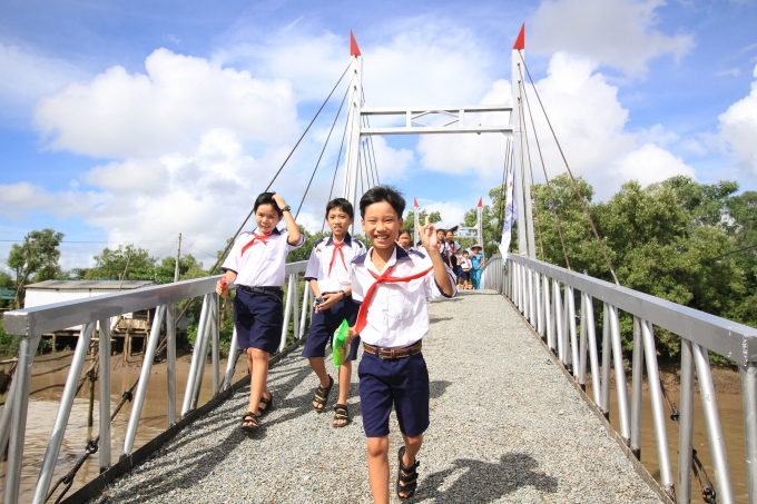 Những em học sinh của trường tiểu học Hiệp Vinh vui mừng đi tr&ecirc;n c&acirc;y cầu mới