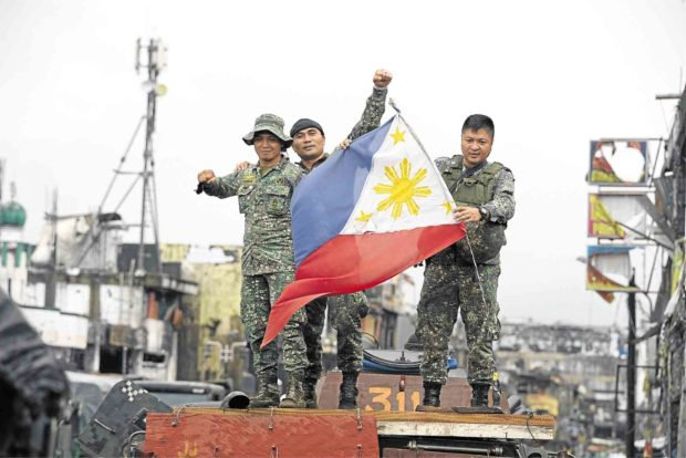 Binh sĩ Philippines vẫy cờ ăn mừng chiến thắng tại Marawi. (Ảnh: AFP)