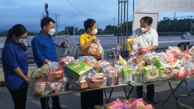 Bà Võ Thị Minh Sinh, Chủ tịch Ủy ban MTTQ tỉnh Nghệ An cùng lực lượng chức năng chuẩn bị đồ ăn tiếp sức cho người dân tại cầu Bến Thủy.